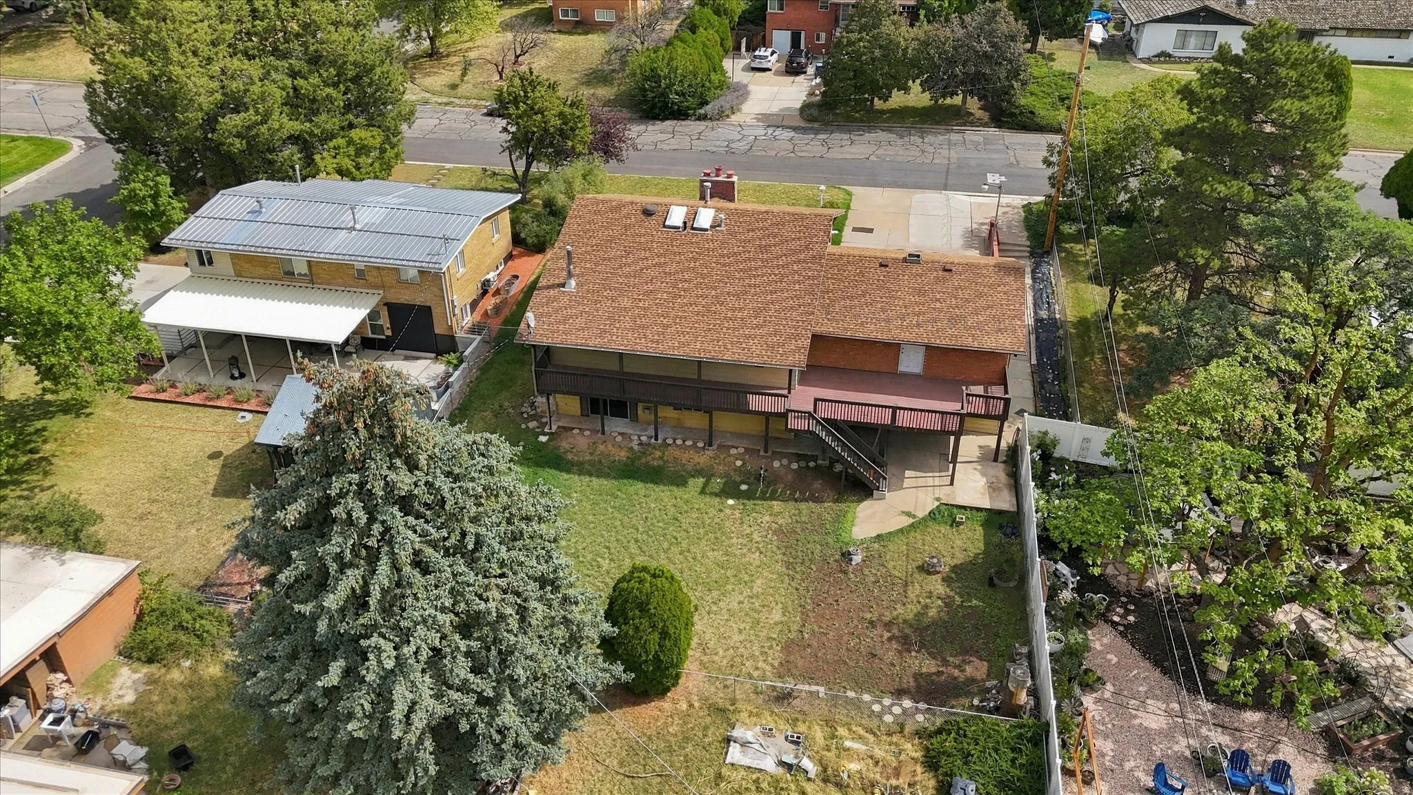 Expansive backyard featuring mature trees and a multi-level deck