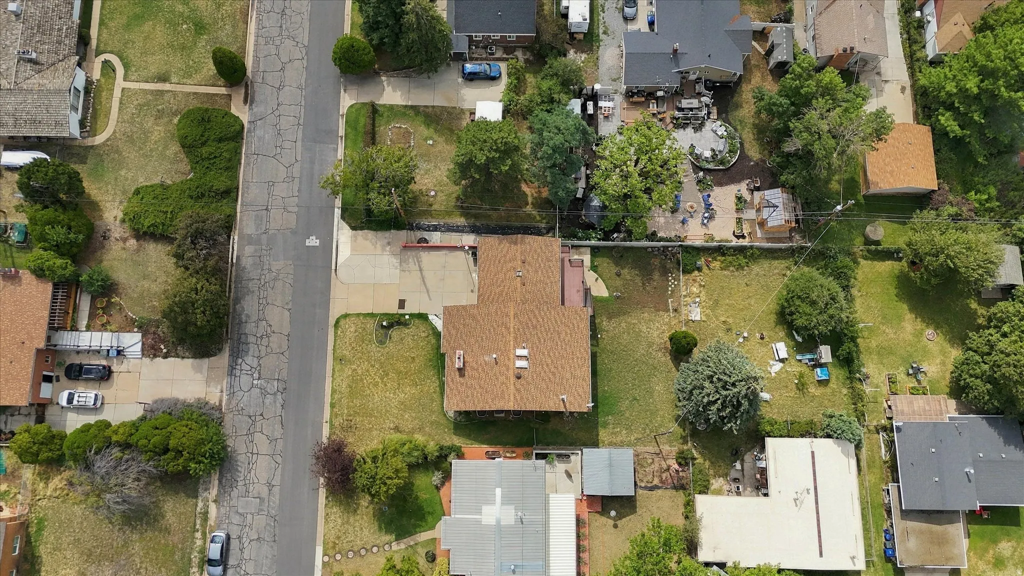 Brown shingle roof with a long driveway and a spacious green lawn