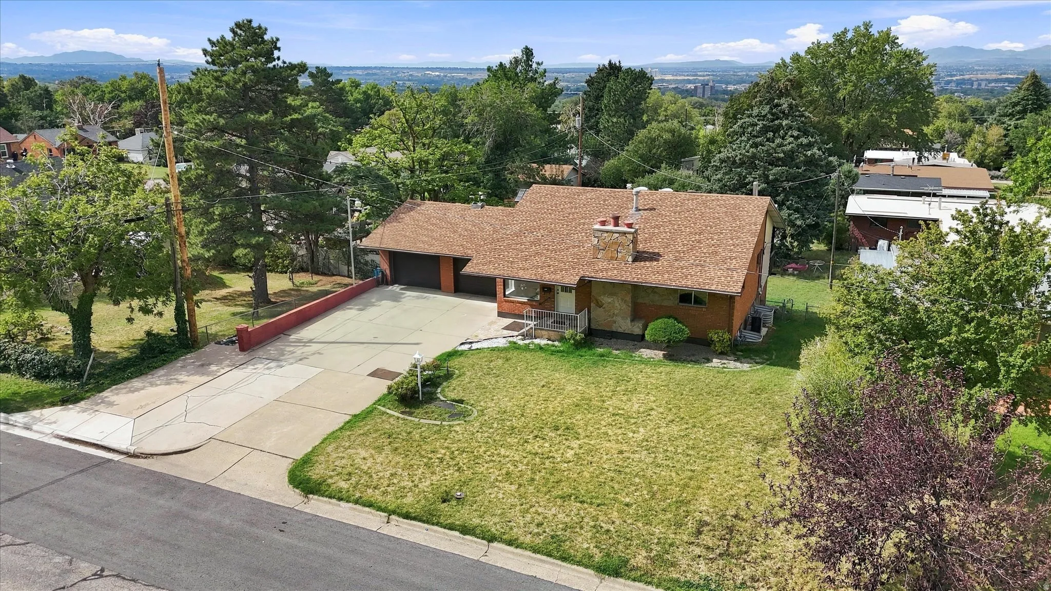 Expansive corner lot with a single-story residence, attached two-car garage, and a large driveway