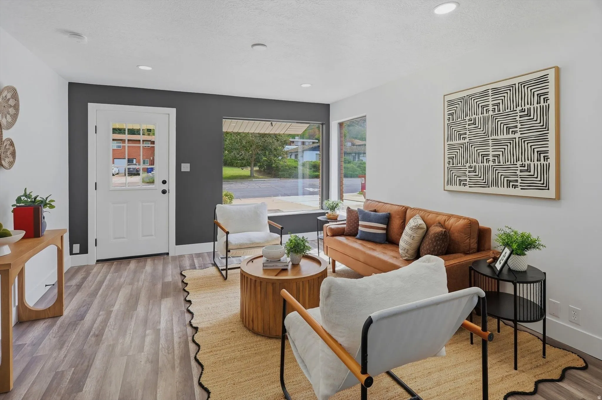 Recessed lighting, wood-finish flooring, white trim, and a white paneled door with glass inserts