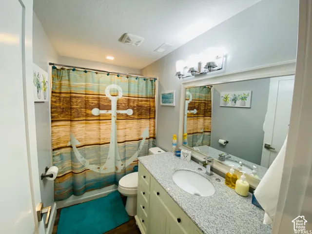 Vanity with granite-style countertop, undermount sink, and matte chrome faucet