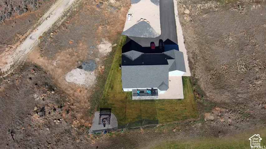 Paved driveway leading to a residence with a gray shingle roof