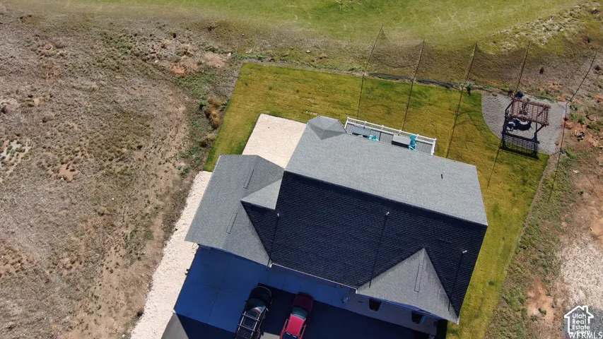 Gable roofline, attached garage, rear deck, and green lawn space