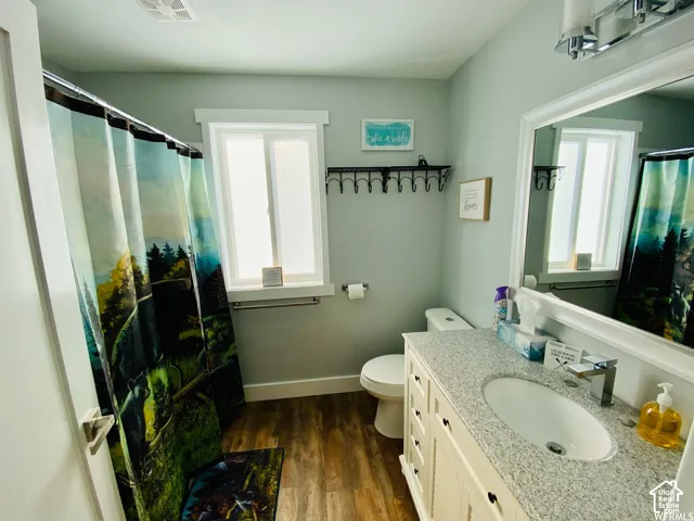 White vanity with a light speckled countertop, undermount sink, and a chrome faucet