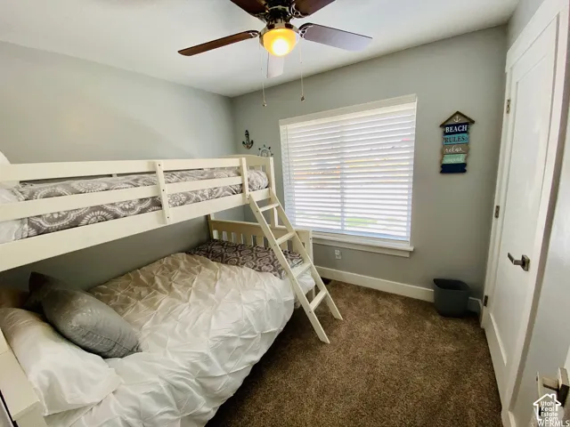 Room featuring a ceiling fan with integrated lighting, a window with blinds, and a white interior door with brushed nickel hardware
