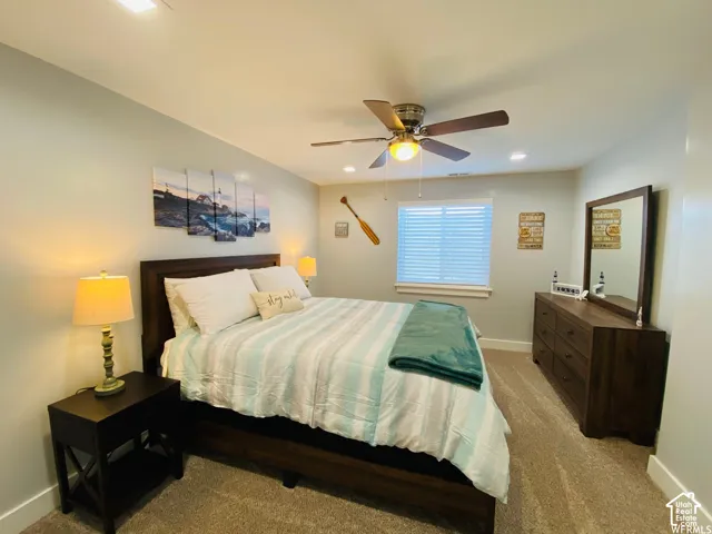 Recessed lighting, ceiling fan with light fixture, window with blinds, wood-finish bed frame, and carpeted flooring