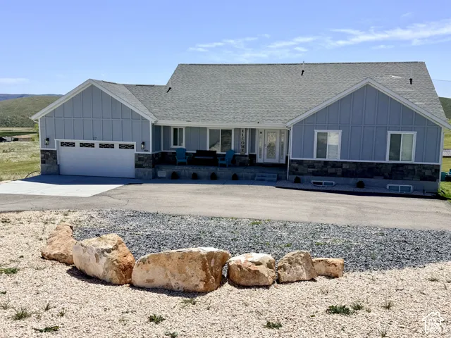 Light blue siding with board and batten accents, a stone facade, and an attached two-car garage