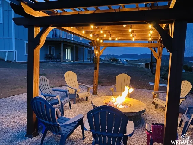 Wood pergola with string lighting and a built-in fire pit