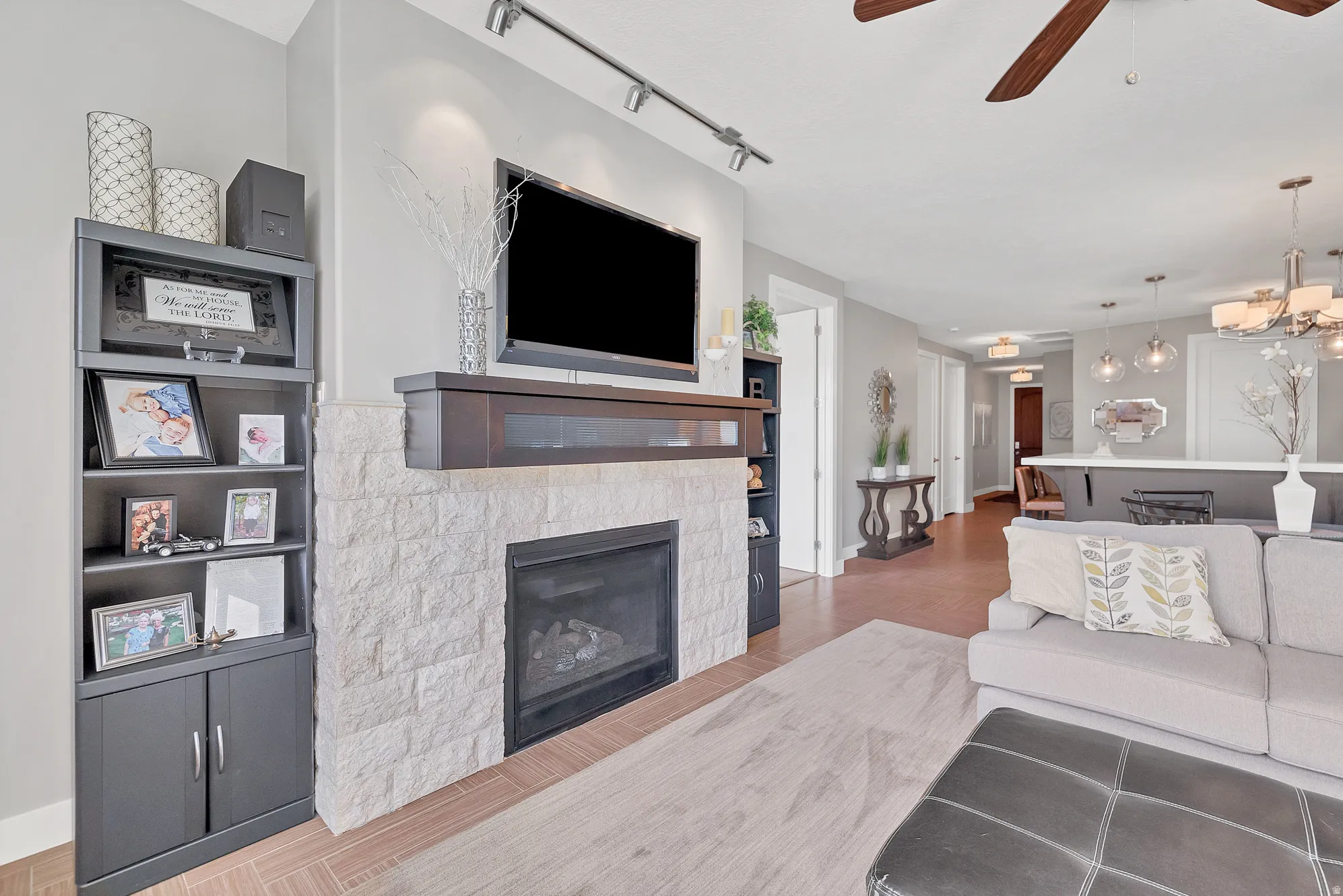 Stone-faced fireplace with a dark wood mantel and built-in shelving