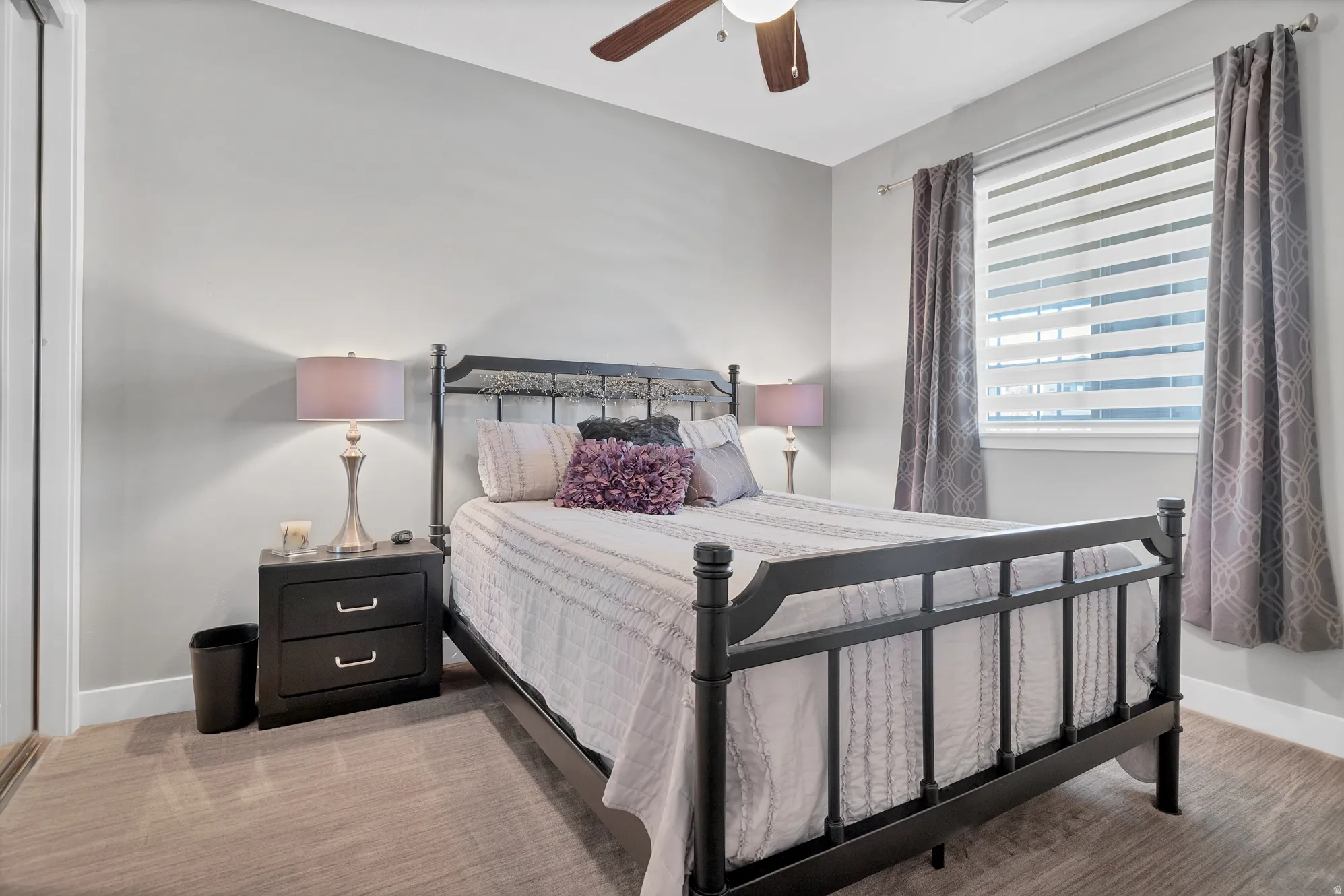 Carpeted flooring, window with blinds, window with drapes, ceiling fan, and painted walls