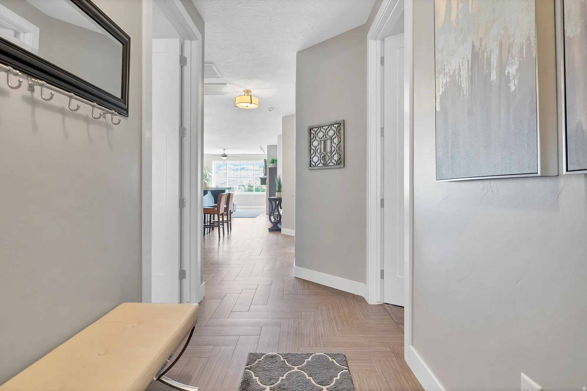 Herringbone wood-finish flooring, light neutral paint, and recessed ceiling lighting