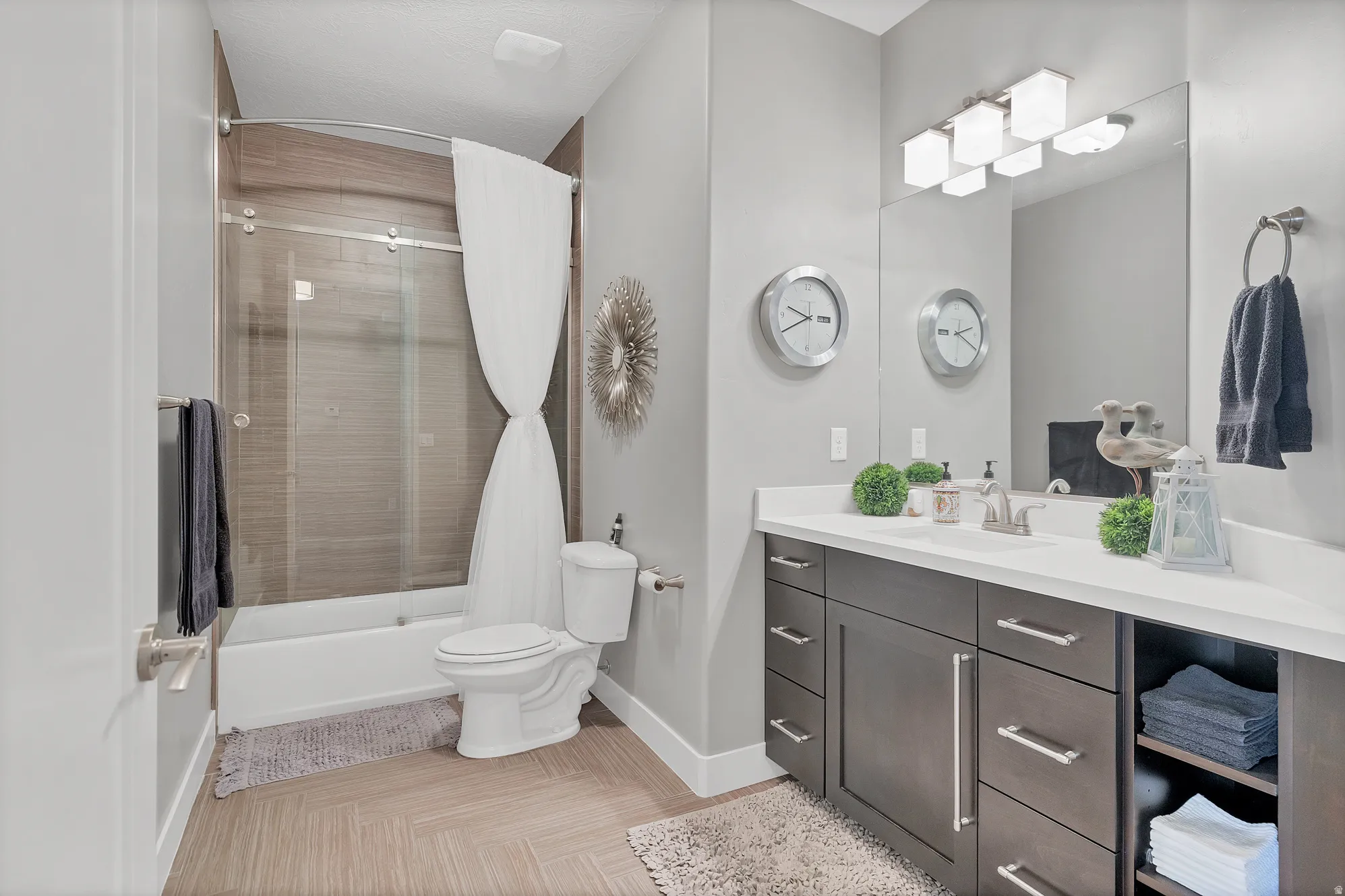 Bathroom featuring a spacious vanity with an integrated sink, ample storage cabinetry, and a framed mirror