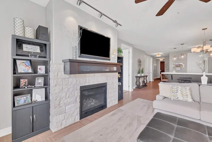 Stone-faced fireplace with a dark wood mantel and built-in shelving
