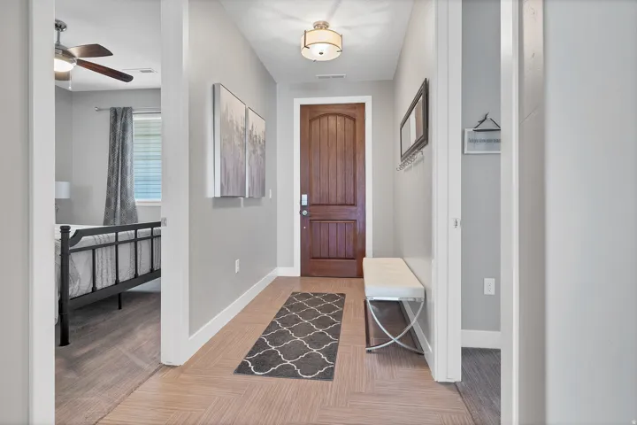Herringbone wood-finish flooring, solid wood entry door, and recessed lighting