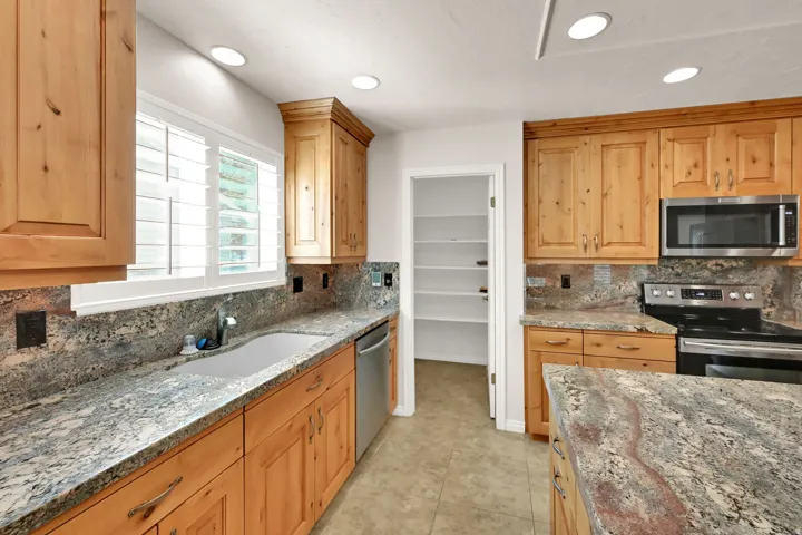 Wood-finish cabinetry paired with patterned stone countertops