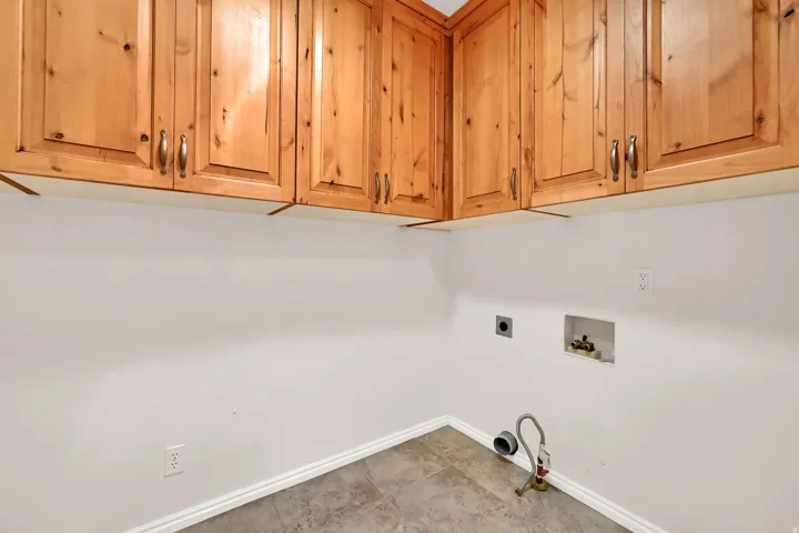 Upper cabinetry with wood panel doors, brushed nickel hardware, and tile flooring