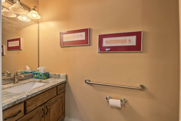 Vanity featuring a built-in sink, stone countertop, and wood-finish cabinetry