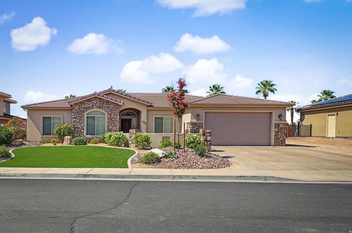 Single-story exterior with stone facade accents, an arched entry, and a two-car garage