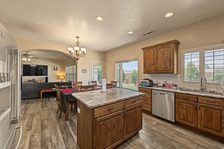Kitchen featuring wood-finish flooring, recessed lighting, and a center island with a stone countertop
