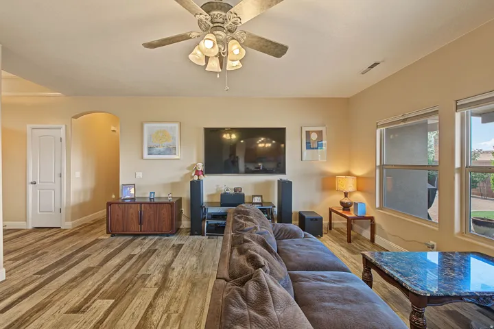 Recessed lighting, wood-finish flooring, ceiling fan with integrated lighting, and multiple windows