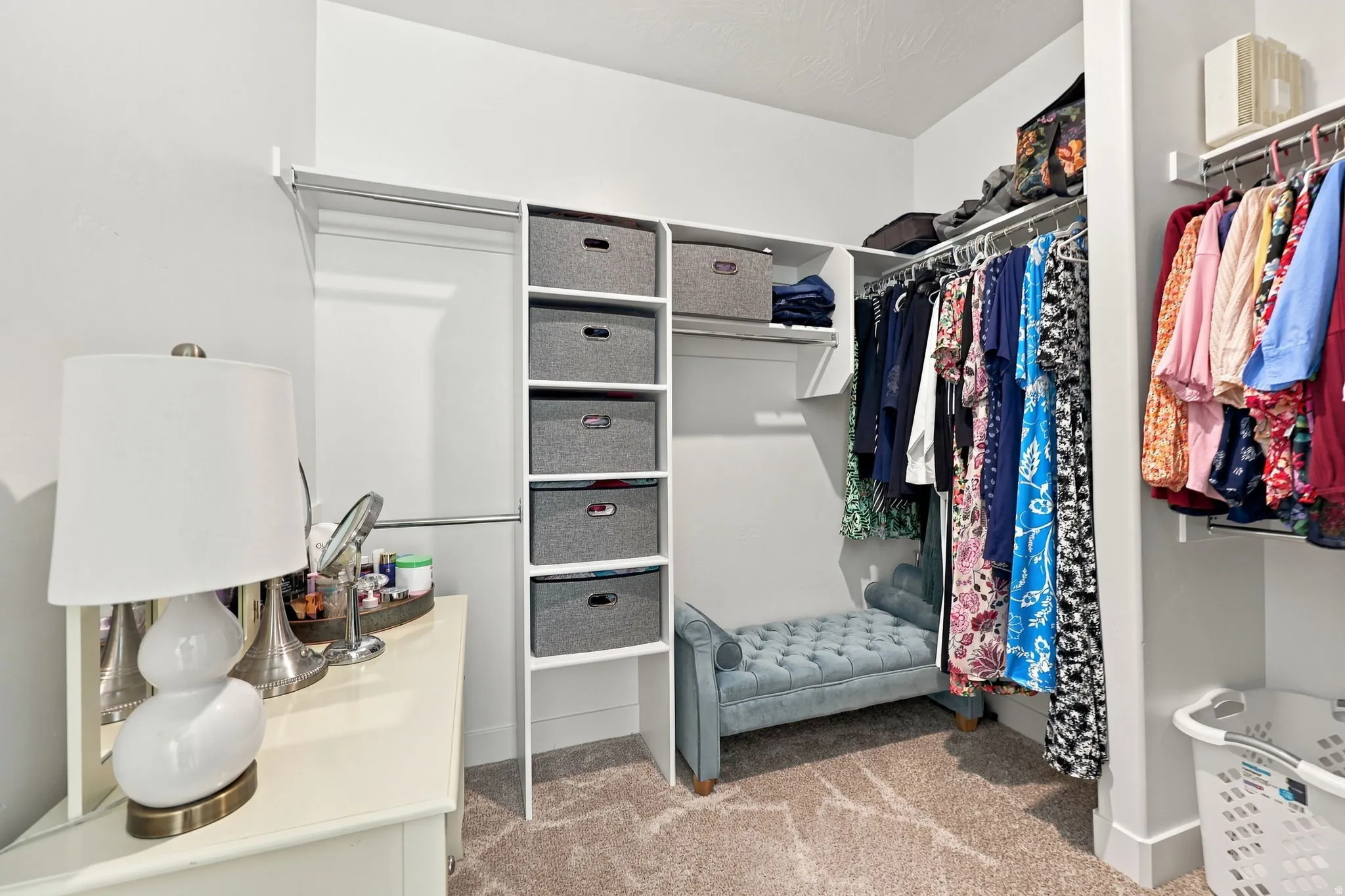 Built-in closet shelving, carpeting, and multiple hanging rods