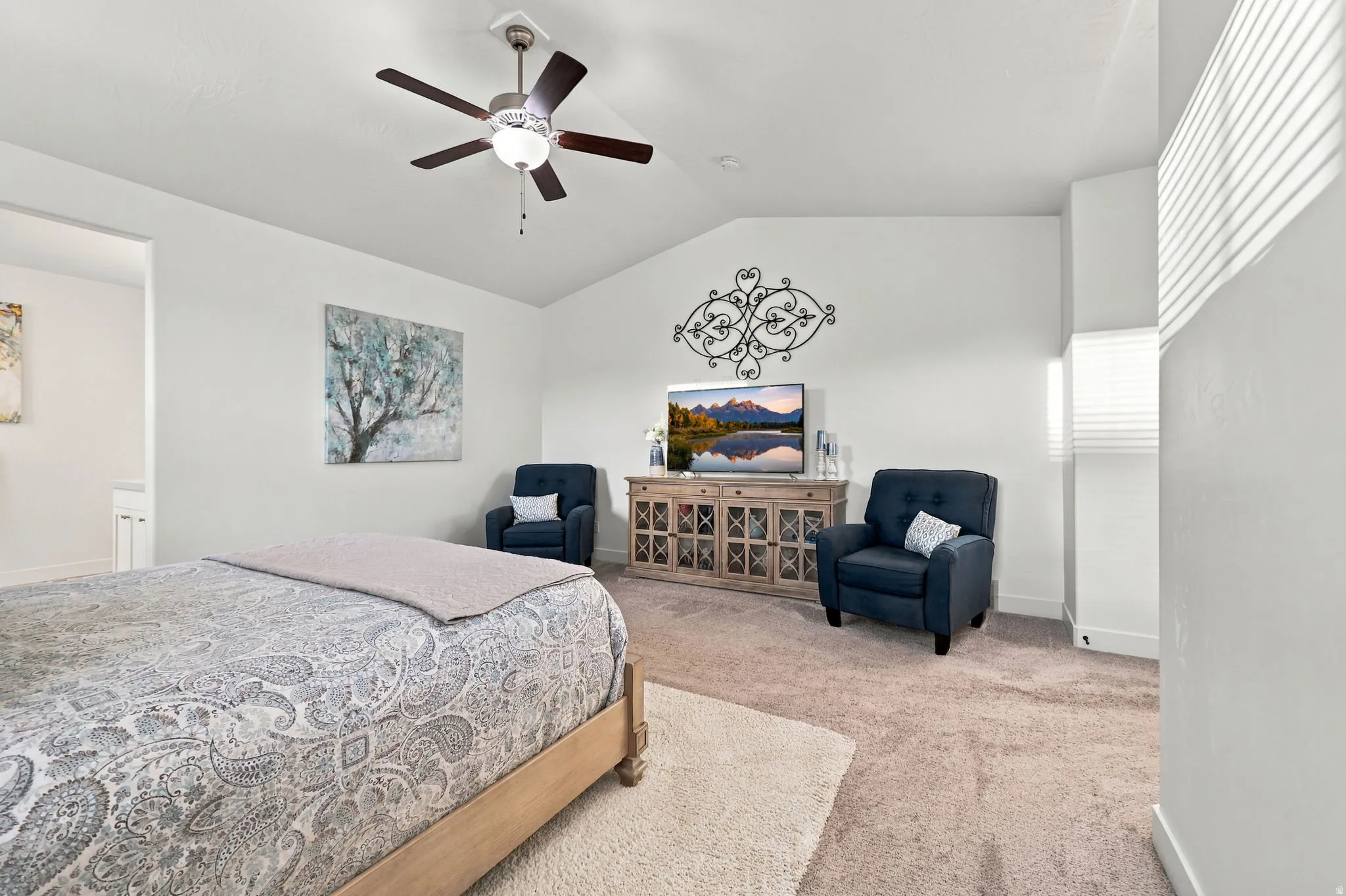 Vaulted ceiling, ceiling fan with integrated lighting, carpeted flooring, window with horizontal blinds, neutral wall tones