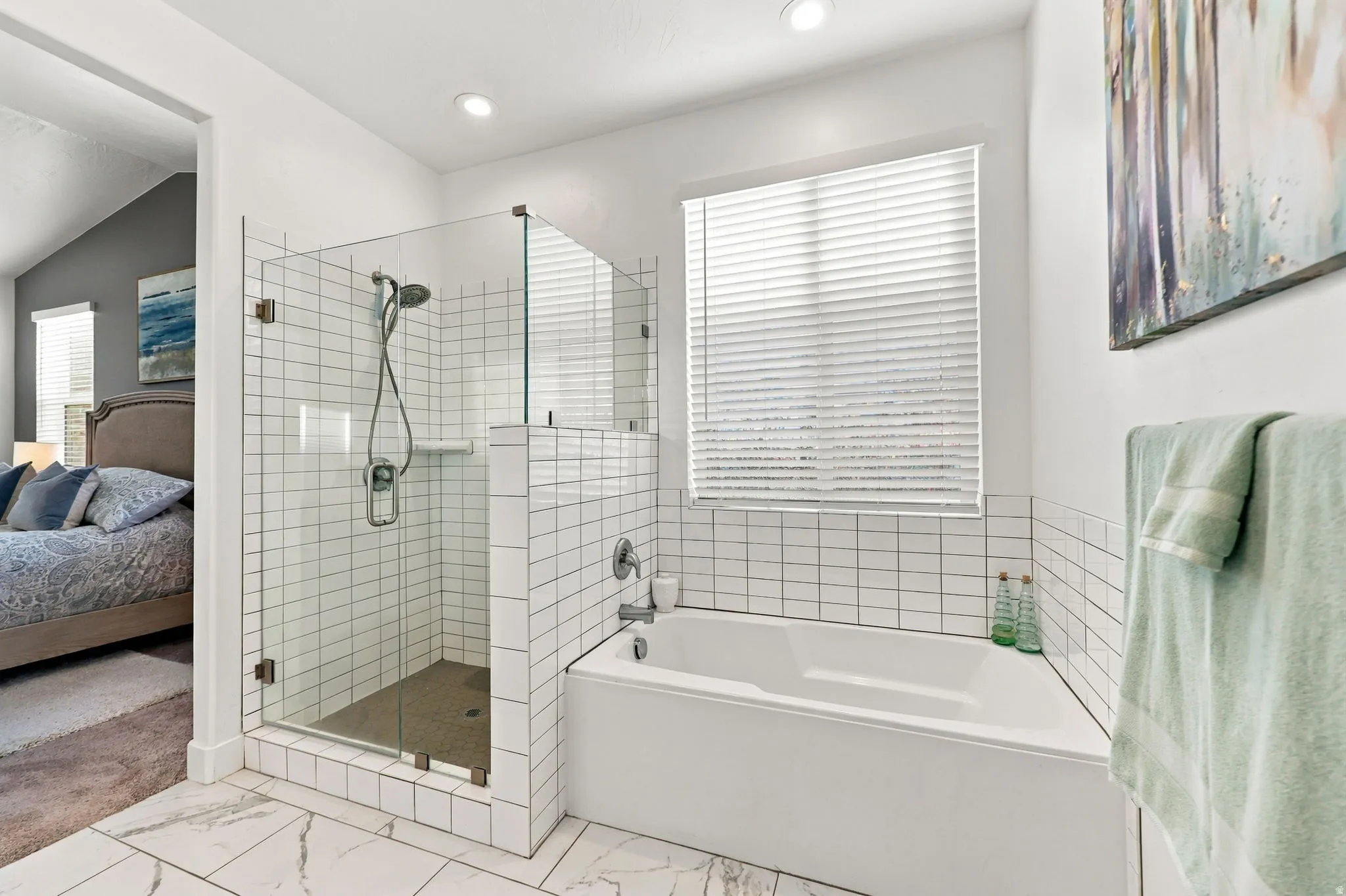 Tiled shower with clear glass enclosure, a built-in bathtub, and white subway tile accents
