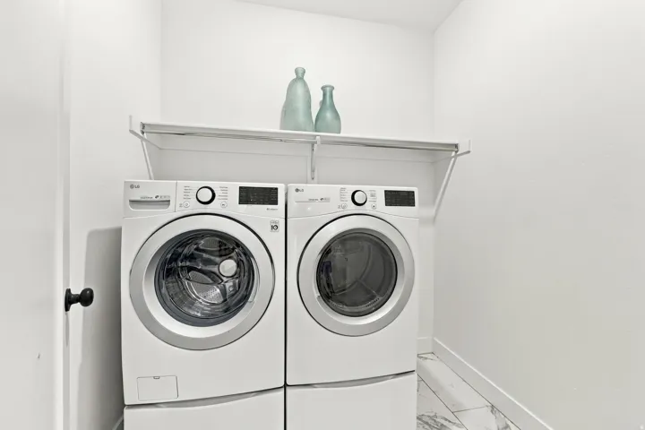 Laundry area featuring a wall-mounted shelf, modern washer and dryer, and white tile flooring