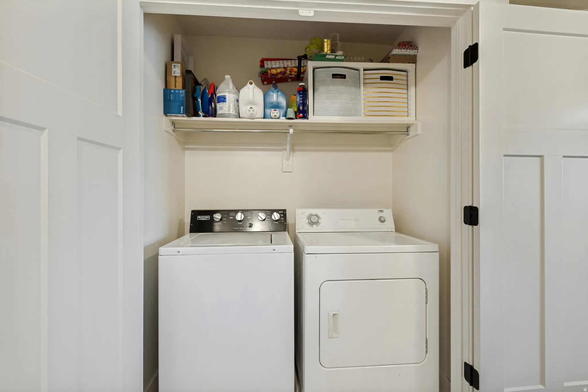 Dedicated laundry area with a top-load washing machine and a front-load dryer