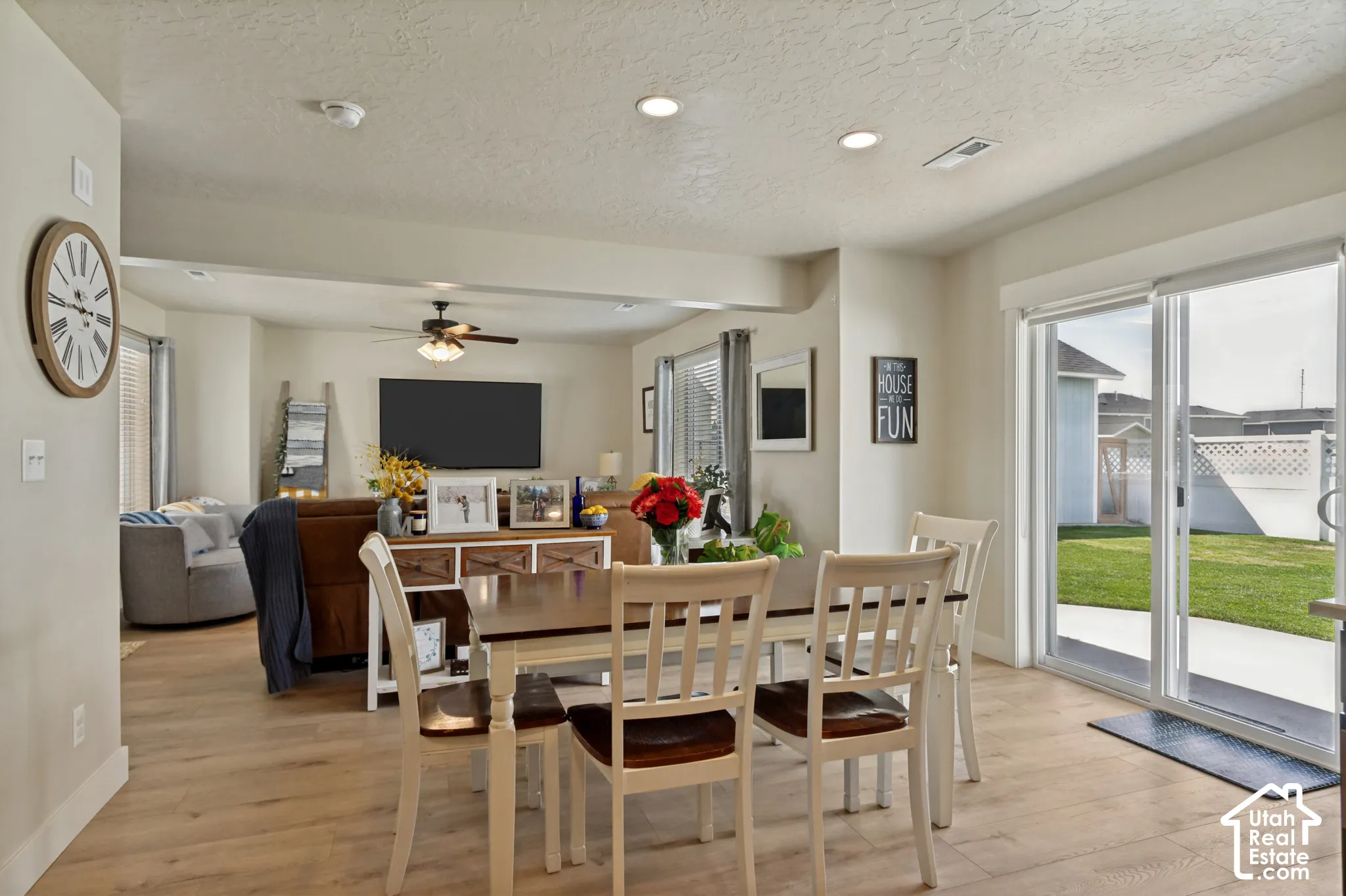 Open-concept living area with wood-finish flooring, recessed lighting, and a ceiling fan