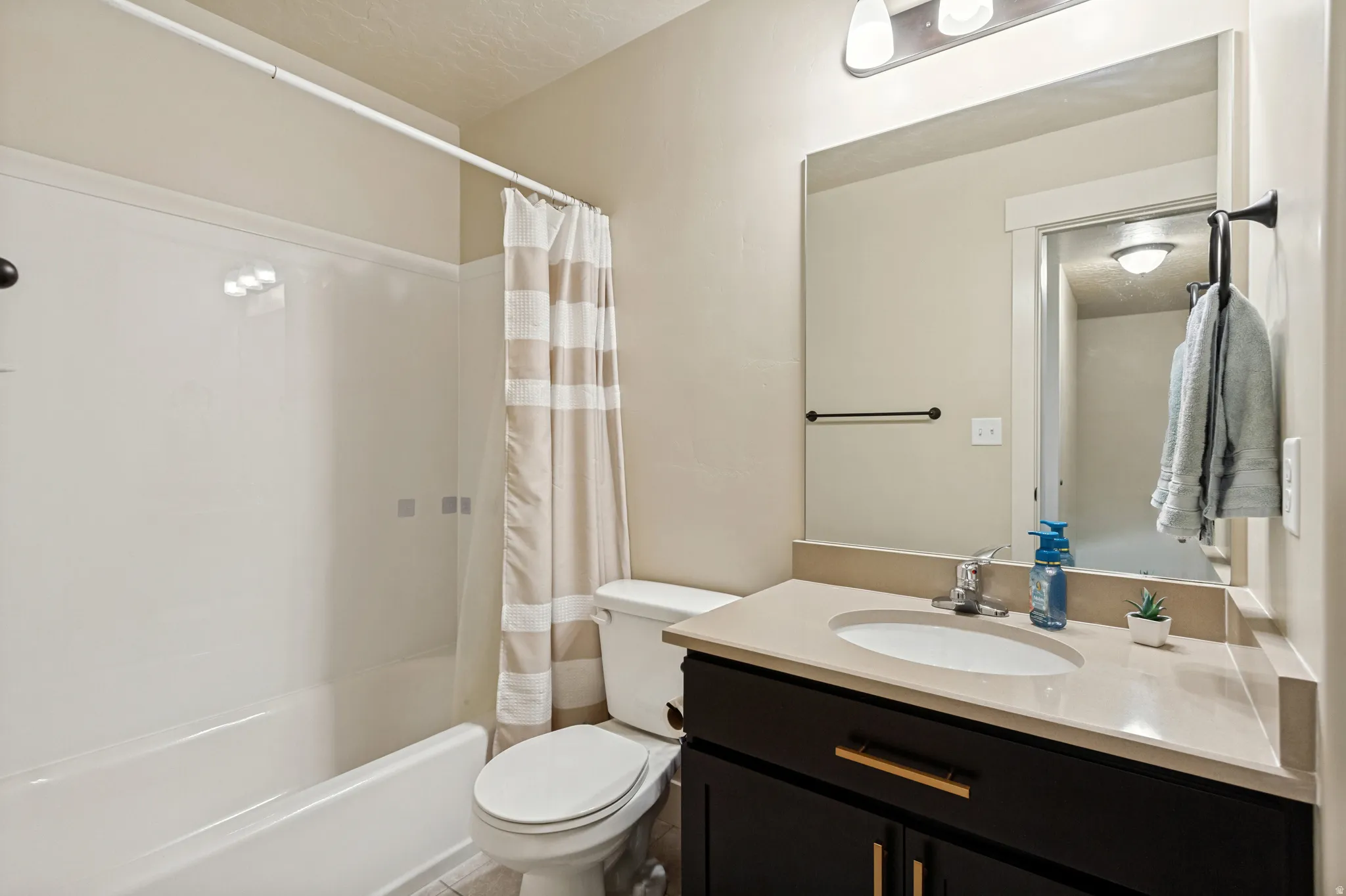 Built-in vanity with a single basin sink, light-toned countertop, and dark wood-finish cabinetry