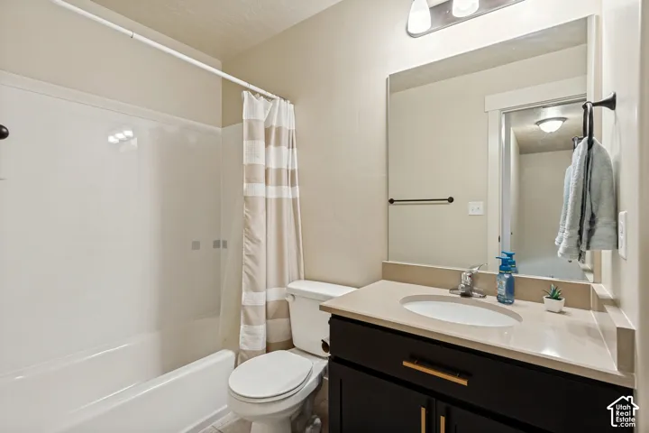 2nd Bathroom featuring a vanity with an integrated sink, a dark wood-finish cabinet with gold-tone hardware, a mirror, and a white shower-over-tub combination
