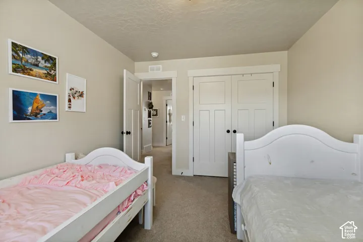 Bedroom. Carpeted flooring, paneled interior doors with dark hardware, recessed lighting, and crisp white trimwork throughout