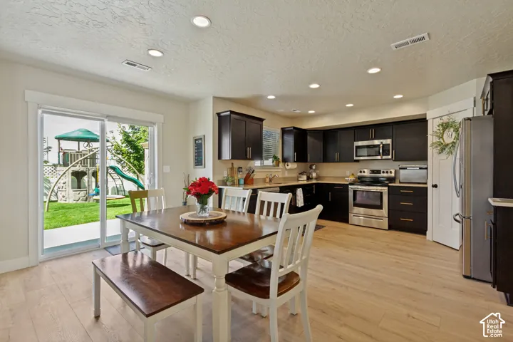 Kitchen with dark wood-finish cabinetry, stainless steel appliances, and recessed lighting