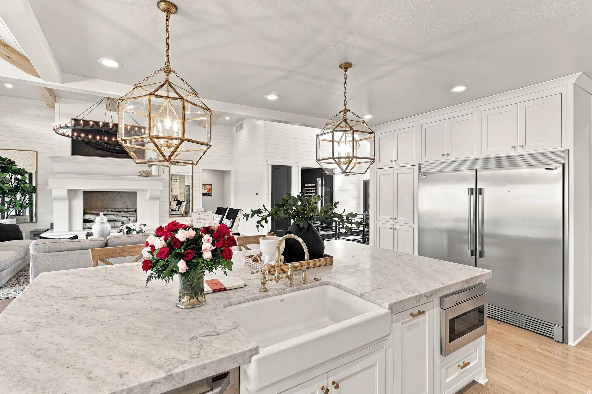 Spacious kitchen island with a farmhouse sink, stainless steel built-in microwave, and pendant lighting