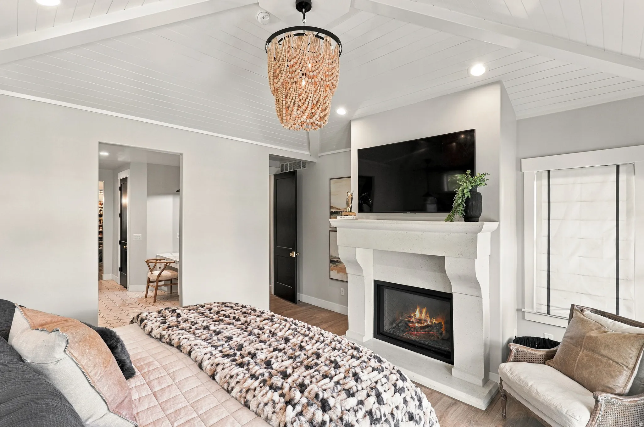 Vaulted shiplap ceiling with exposed beams, decorative chandelier, built-in fireplace with stone-finish mantel, recessed lighting, and wood-finish flooring