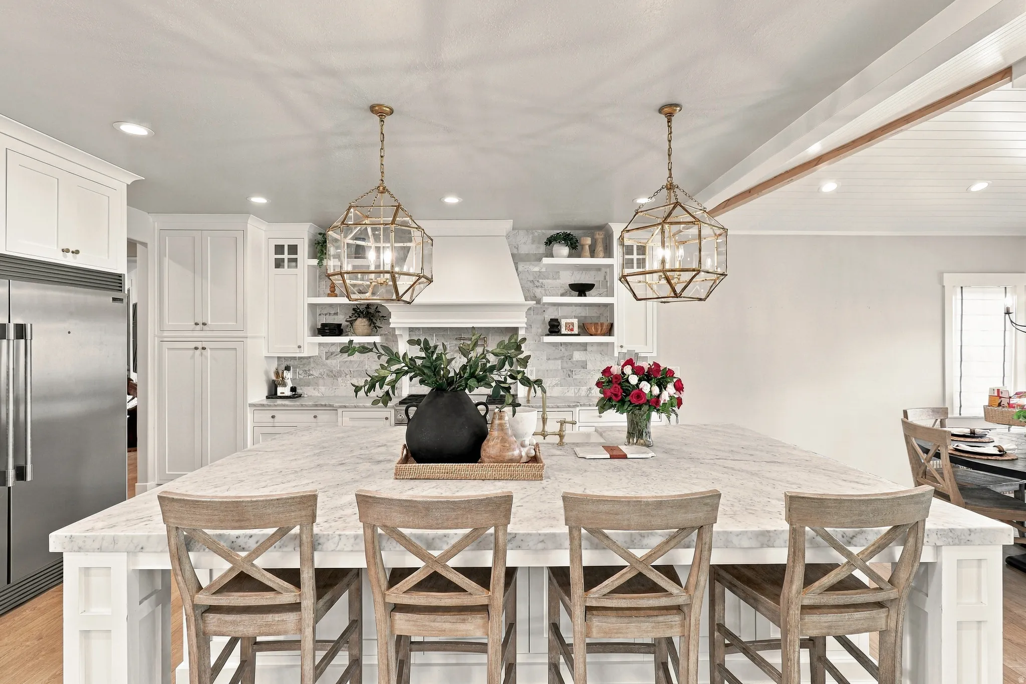 Expansive kitchen island with a light-toned countertop, flanked by two geometric pendant lights