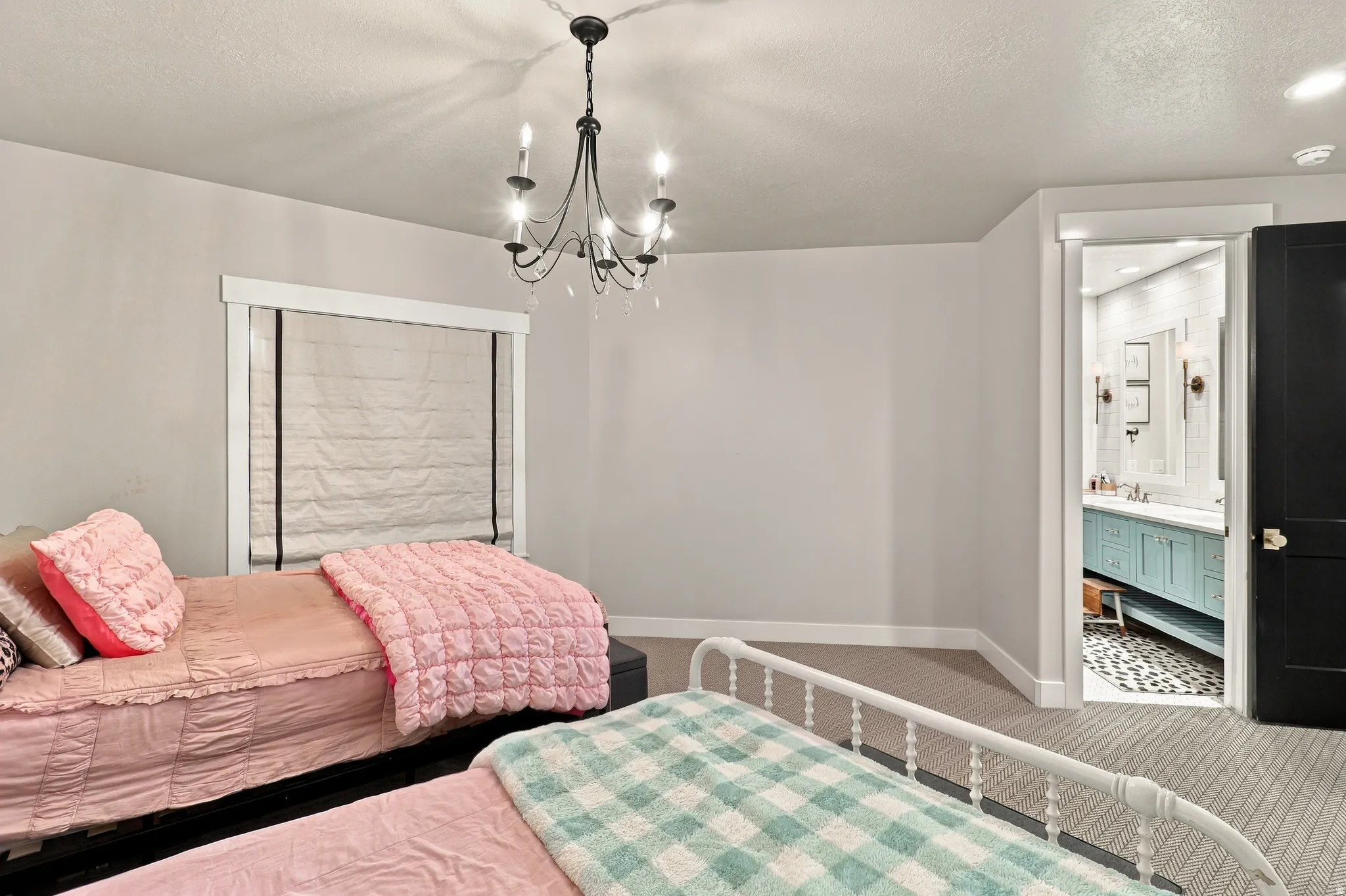 Carpeted room featuring a chandelier and a window with blinds