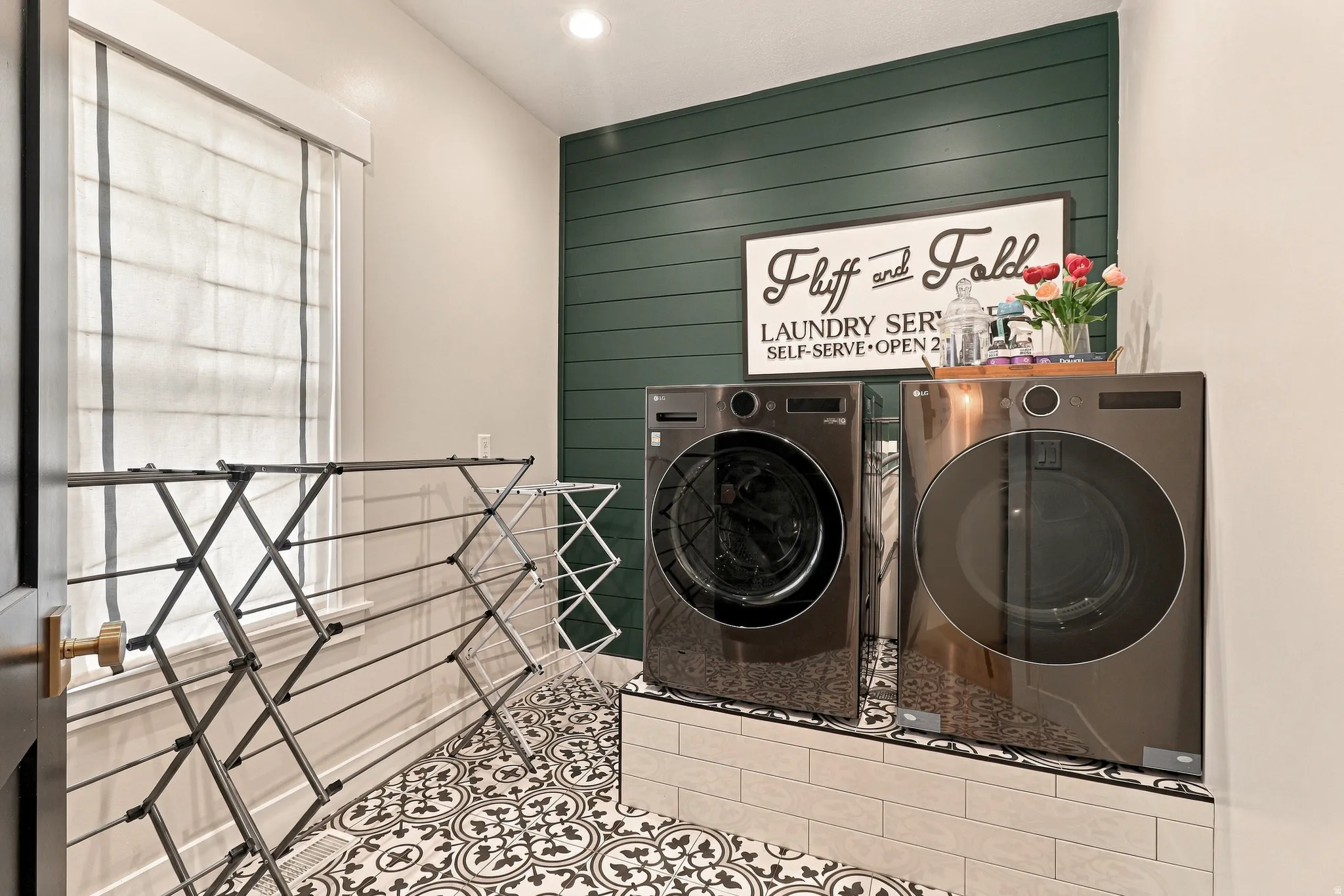 Patterned floor tile, dark green shiplap accent wall, white window treatments, recessed lighting, and wall-mounted appliances