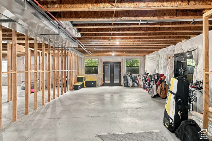 Unfinished basement with concrete flooring, exposed wood joists, and framed interior walls