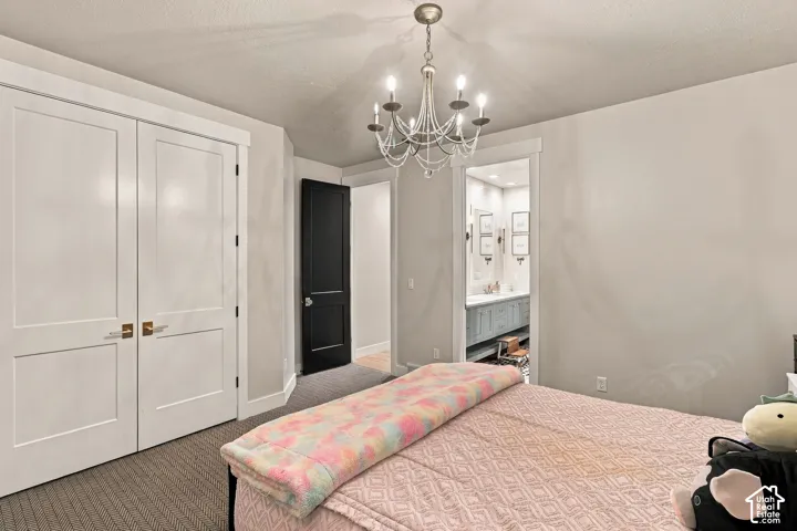 White paneled closet doors with bronze hardware, dark paneled interior door, and a crystal chandelier