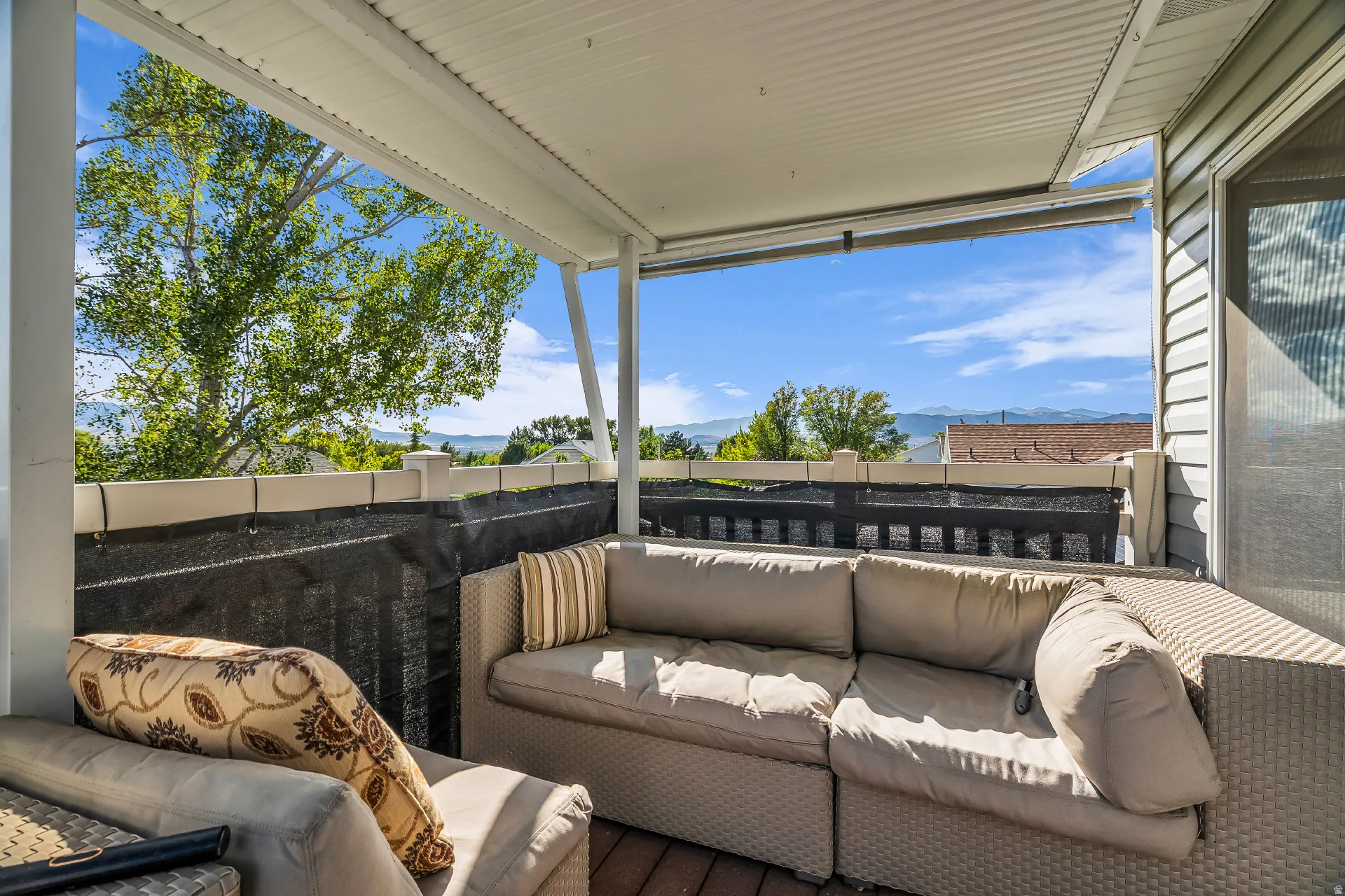 Upper deck covered outdoor patio featuring brown trex flooring