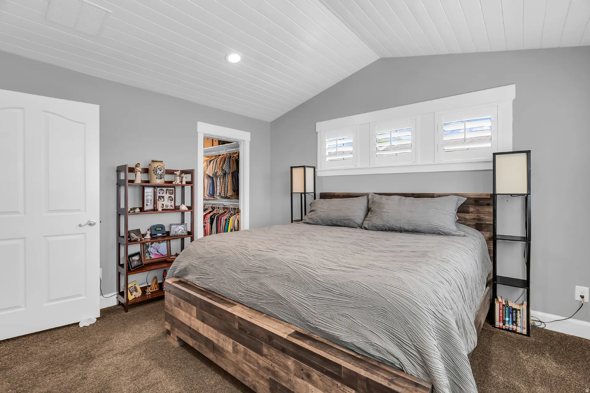 Vaulted ceiling with shiplap detailing, recessed lighting, and three transom windows featuring plantation shutters