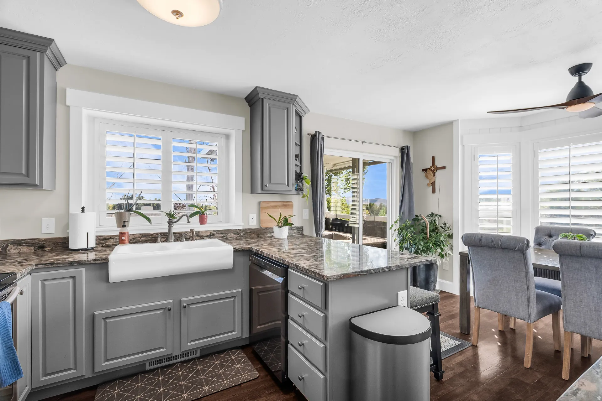 Kitchen featuring shaker-style cabinetry, a white farmhouse sink, and stone countertops