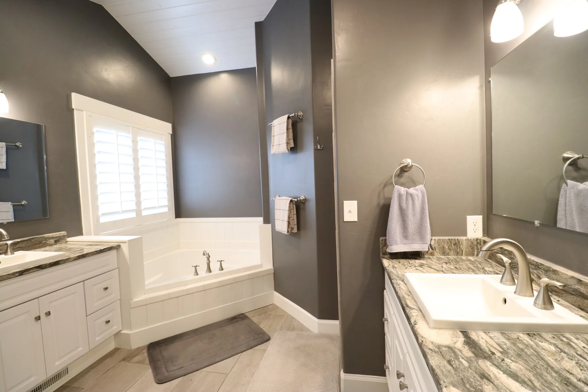Dual vanity with stone-finish countertops, undermount sinks, and brushed nickel fixtures