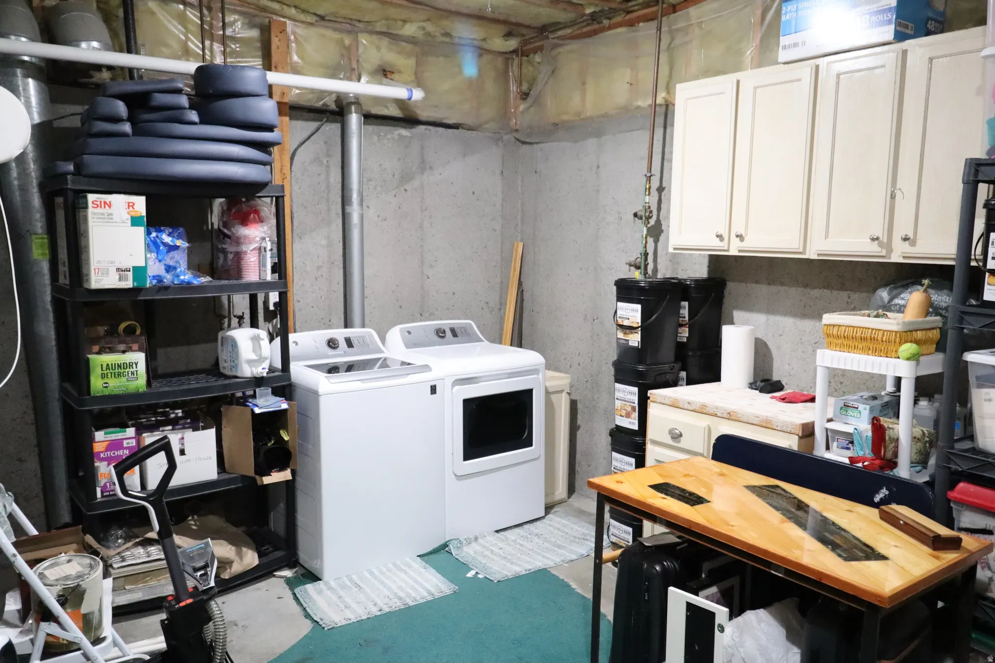 Large open laundry room with plenty of storage space, in basement level.
