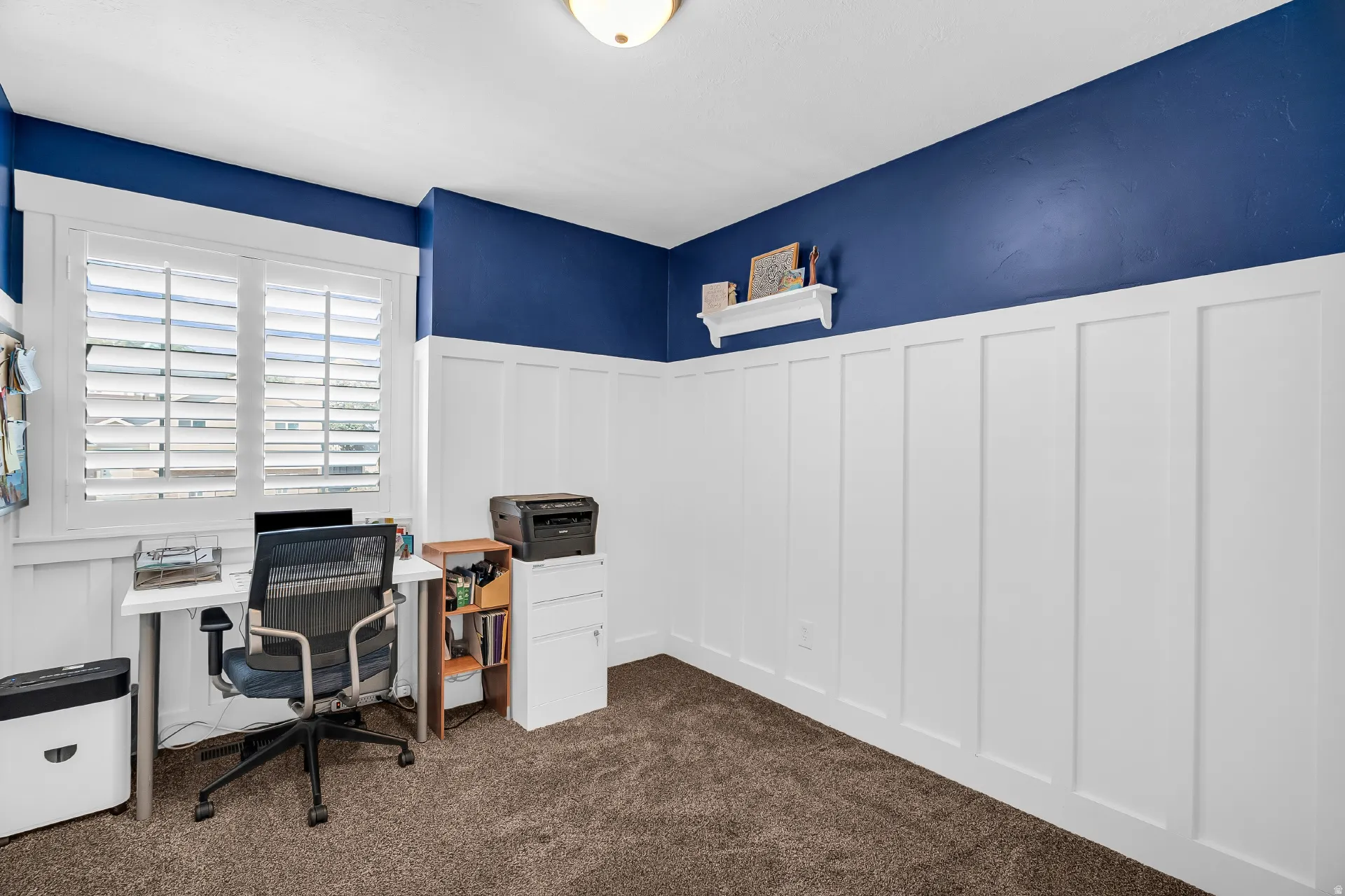 Decorative wainscoting paneling office, with plantation shutters
