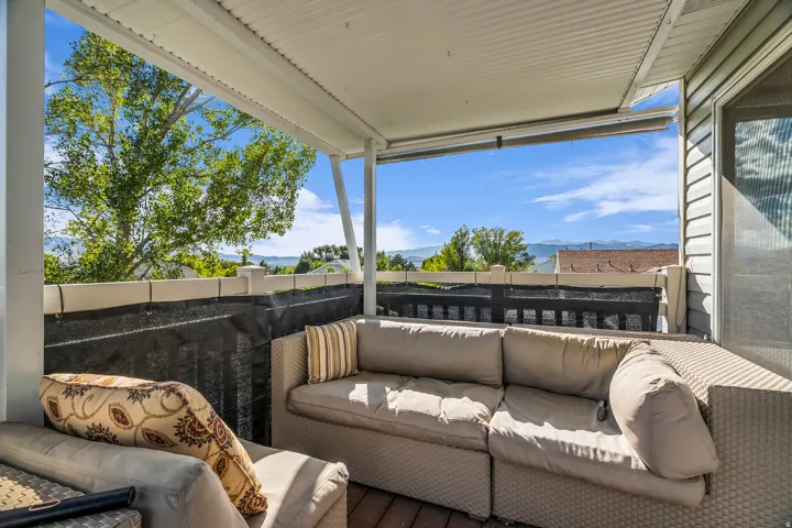 Upper deck covered outdoor patio featuring brown trex flooring