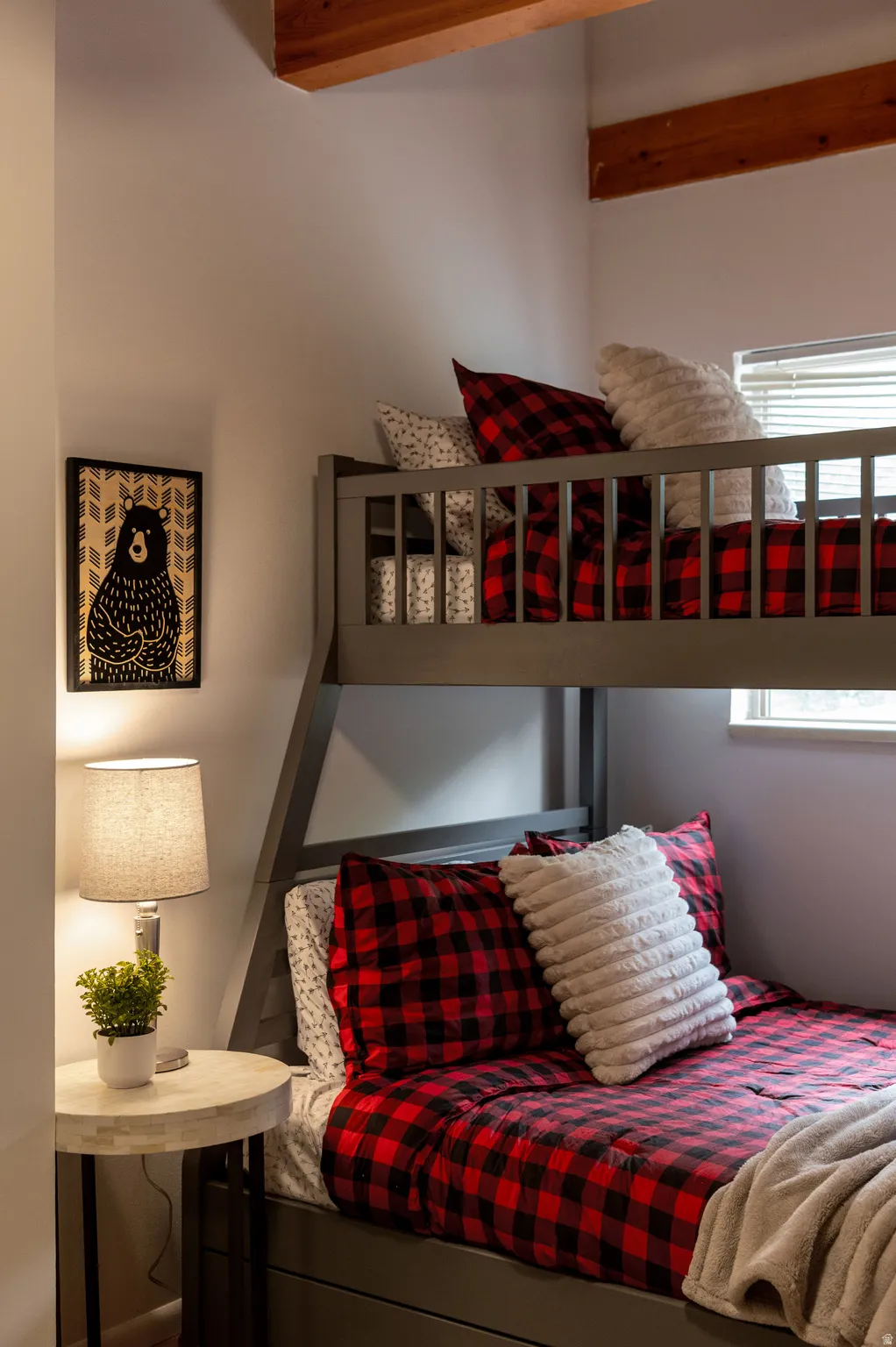 Gray bunk bed with integrated storage drawers and exposed ceiling beams
