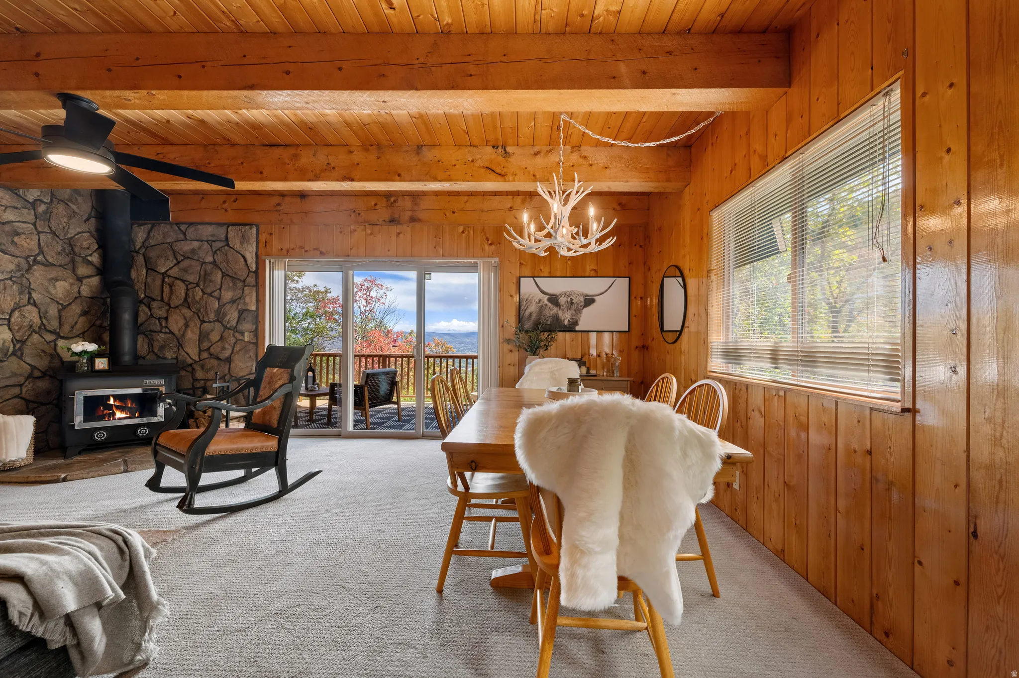 Warm wood-paneled great room with vaulted beam ceiling and antler chandelier